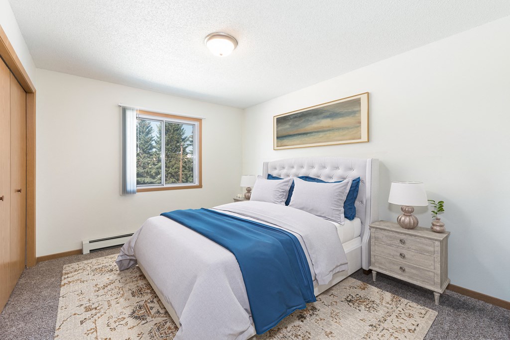 Bismarck, ND Sierra Ridge Apartments The room showcases a peaceful ambiance with a cozy bed, stylish furnishings, and soft lighting from the window