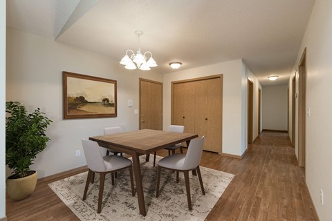 Bismarck, ND Sierra Ridge Apartments. The room showcases a modern dining table with four elegant chairs, well-placed lighting, and a sophisticated ambiance for enjoyable meals and gatherings.
