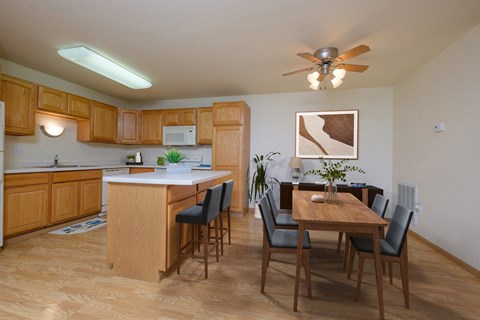 a kitchen and dining room with a wooden table and chairs