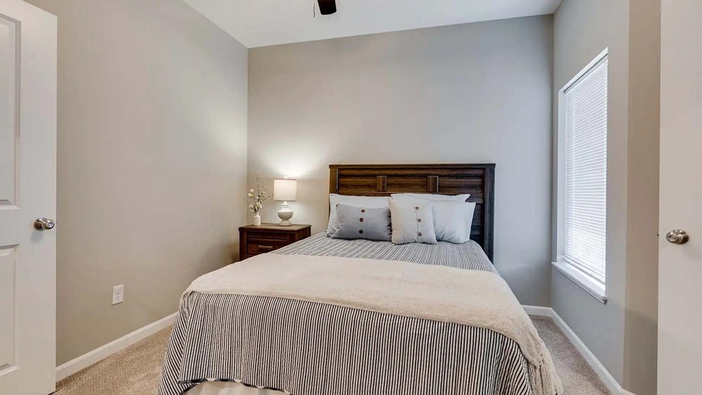 a bedroom with a bed and a window. Circle Pines, MN Lexington Lofts