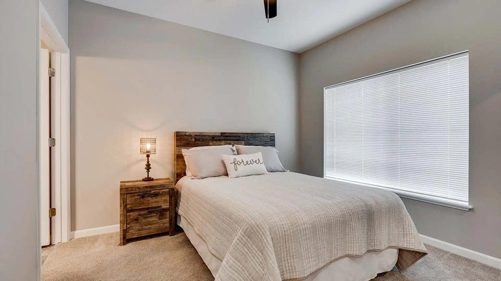 a bedroom with a bed and a window.  Circle Pines, MN Lexington Lofts