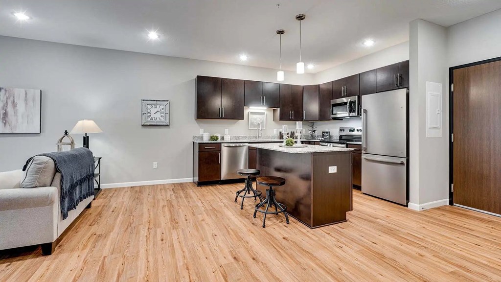 a kitchen with stainless steel appliances and a wooden floor. Circle Pines, MN Lexington Lofts