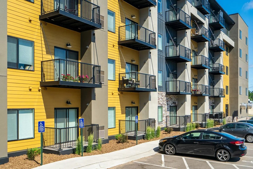 an apartment with balconies and cars parked in front of them. Circle Pines, MN Lexington Lofts