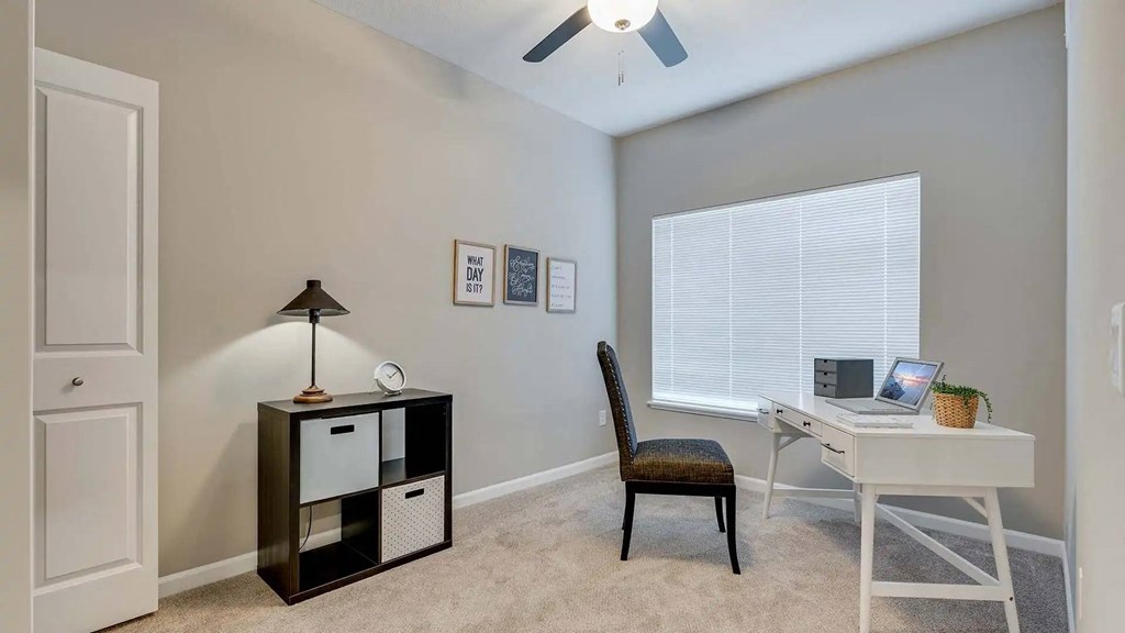 a bedroom with a desk and a chair and a window. Circle Pines, MN Lexington Lofts