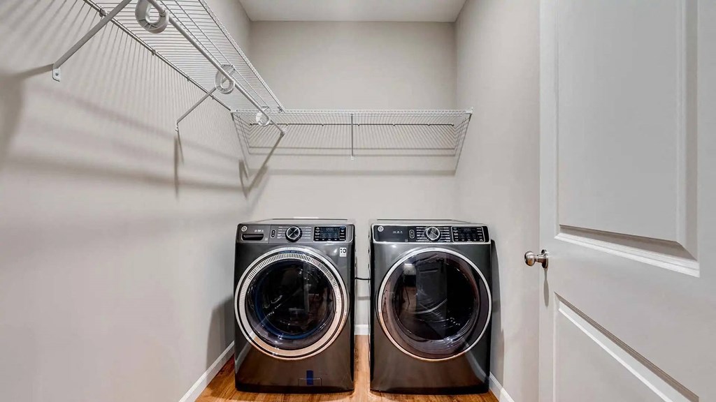 a washer and dryer in a laundry room with a white closet. Circle Pines, MN Lexington Lofts