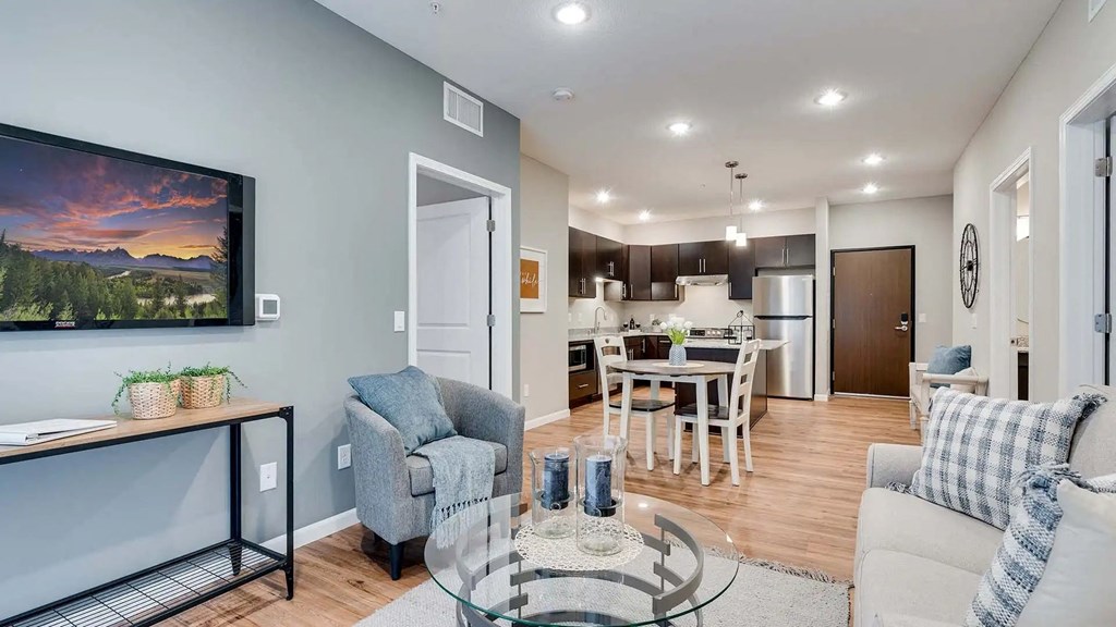 a living room with a couch and a table in front of a kitchen. Circle Pines, MN Lexington Lofts