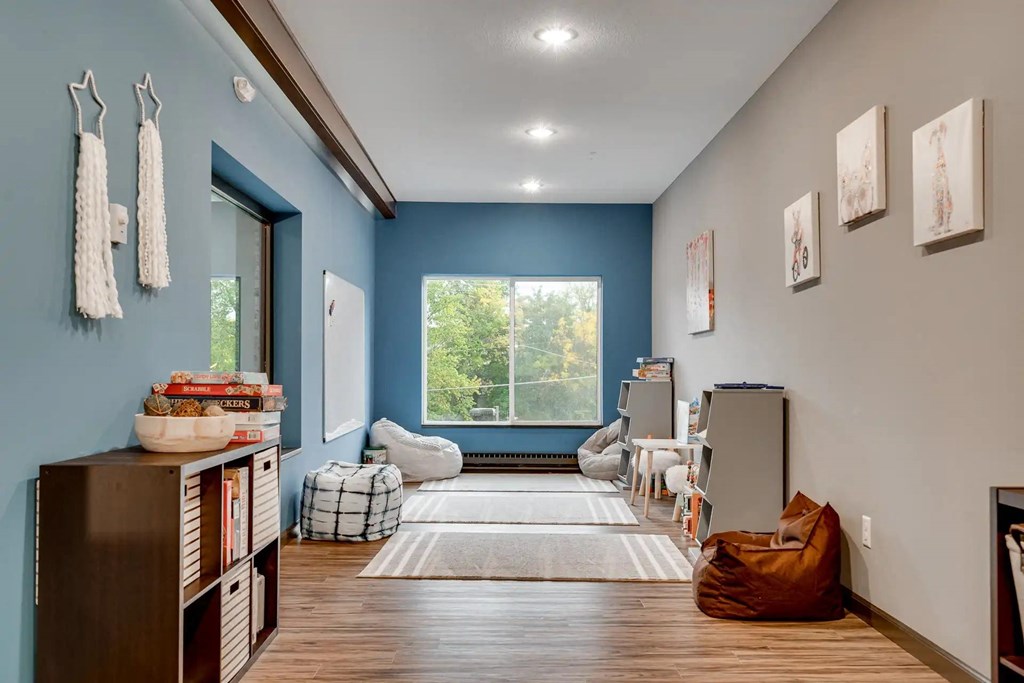 a living room with blue walls and a large window. Circle Pines, MN Lexington Lofts
