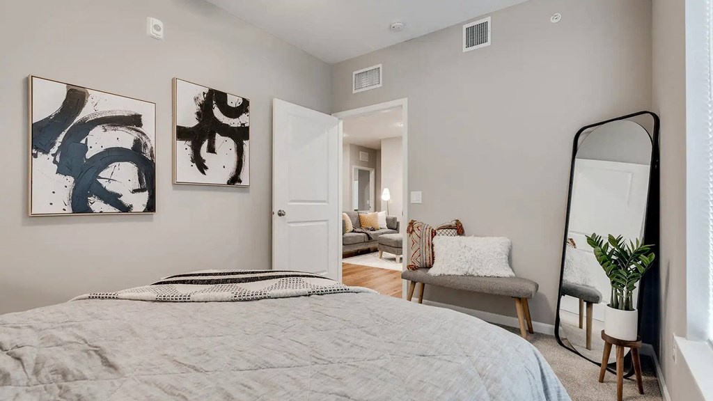a bedroom with a bed and a mirror.. Circle Pines, MN Lexington Lofts