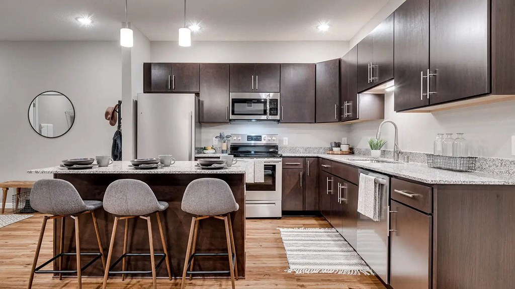a kitchen with stainless steel appliances and wooden cabinets. Circle Pines, MN Lexington Lofts
