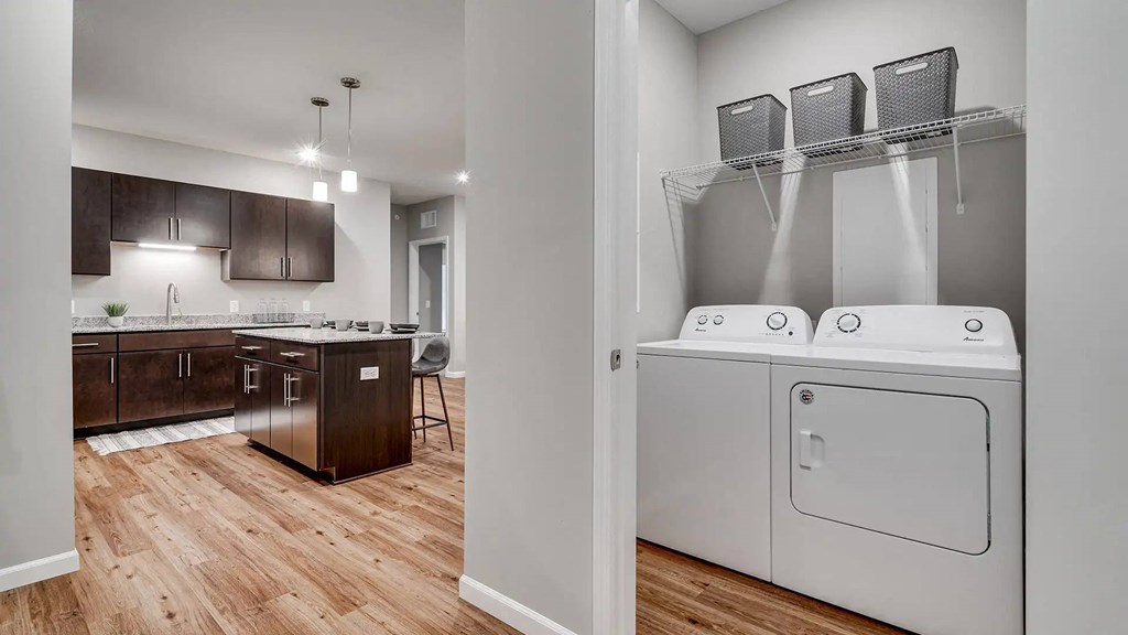 a washer and dryer in a room with a kitchen. Circle Pines, MN Lexington Lofts