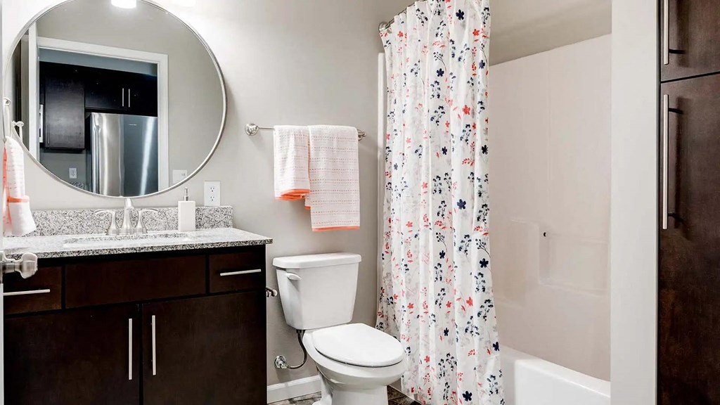 a bathroom with a shower and a toilet and a sink. Circle Pines, MN Lexington Lofts