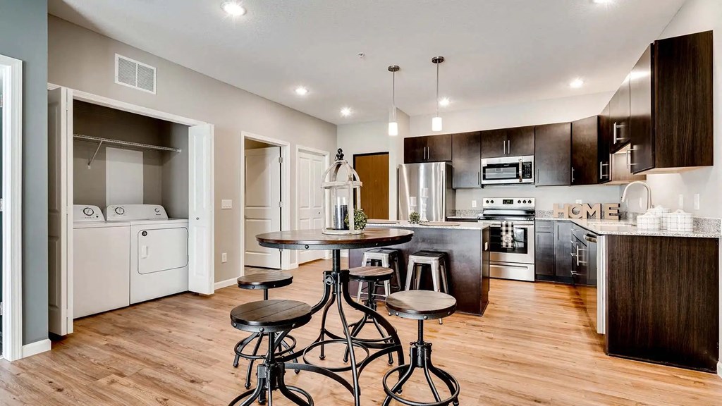 an open kitchen and dining room with a bar and stools. Circle Pines, MN Lexington Lofts