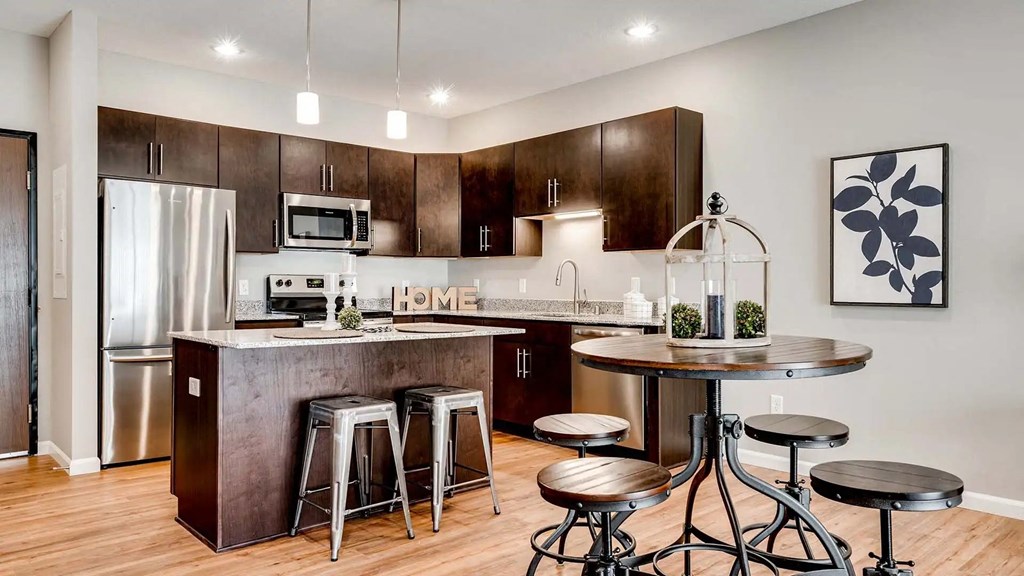 a kitchen with a counter and a bar with stools. Circle Pines, MN Lexington Lofts