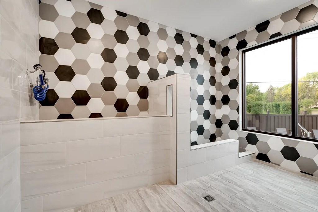 a bathroom with black and white tiles on the wall. Circle Pines, MN Lexington Lofts