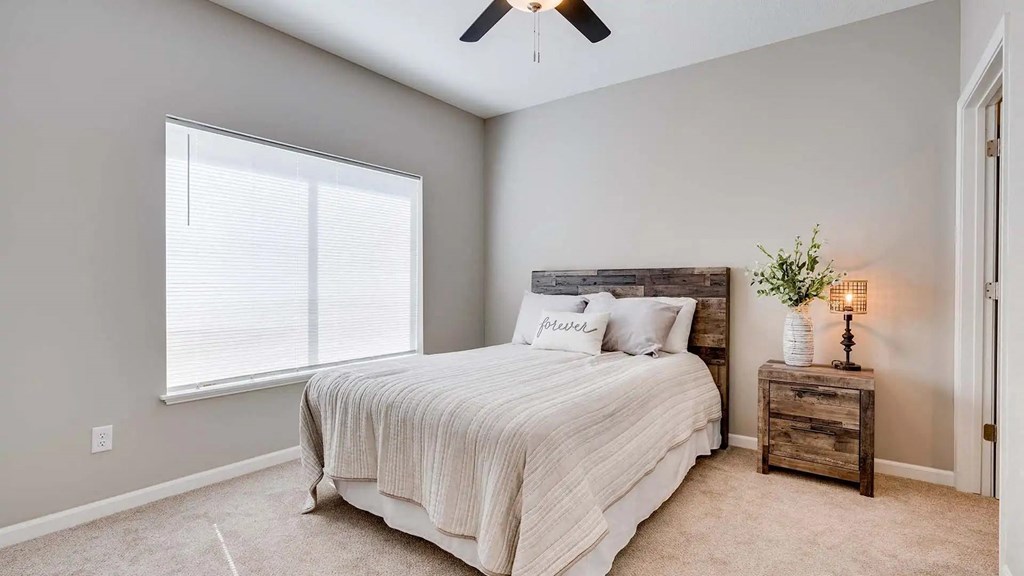 a bedroom with a bed and a window. Circle Pines, MN Lexington Lofts