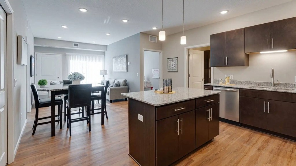 an open kitchen and dining room with a table and chairs. Circle Pines, MN Lexington Lofts