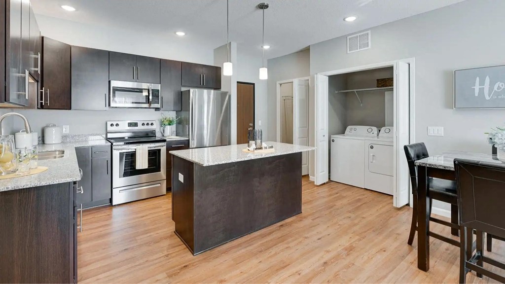 an open kitchen with a large island in the middle. Circle Pines, MN Lexington Lofts