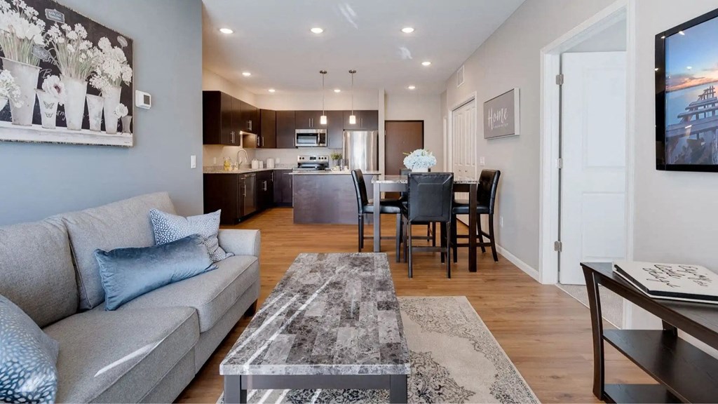 a living room and kitchen with a couch and a table. Circle Pines, MN Lexington Lofts