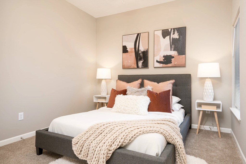a bedroom with a bed and paintings on the wall. Circle Pines, MN Lexington Lofts