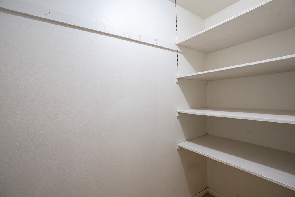an empty closet in a room with white walls and shelves. Fargo, ND Betty Ann Apartments