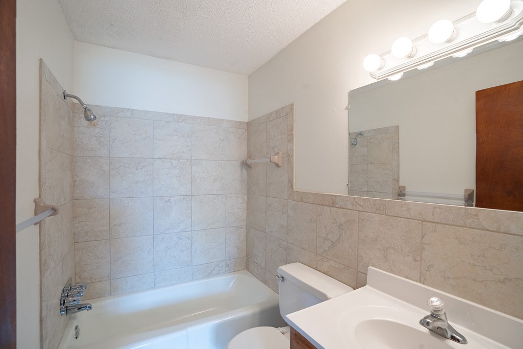 a bathroom with a sink toilet and a bath tub. Coon Rapids, MN Robinwood Apartments