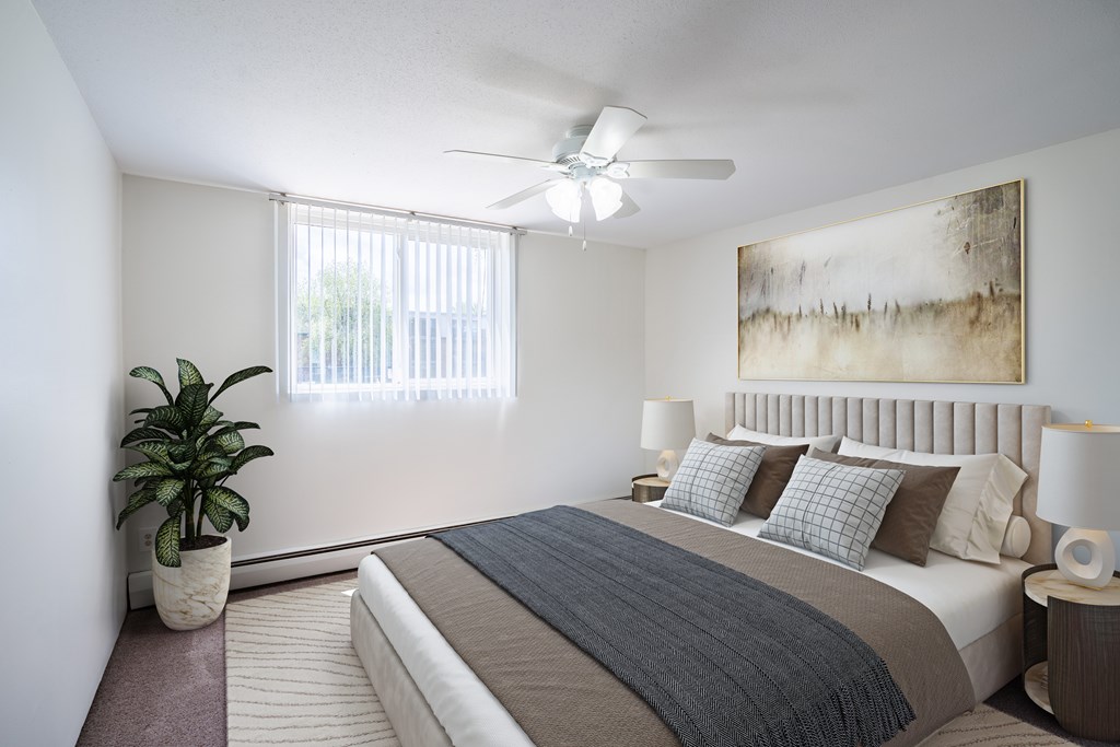 Coon Rapids, MN Robinwood Apartments | Bedroom a bedroom with a bed and a ceiling fan. Coon Rapids, MN Robinwood Apartments