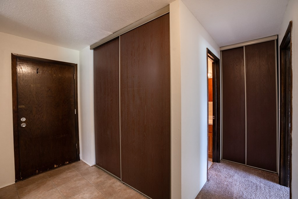 a closet with two doors and a door to a bathroom. Coon Rapids, MN Robinwood Apartments