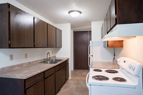 a kitchen with white appliances and wooden cabinets and a white stove