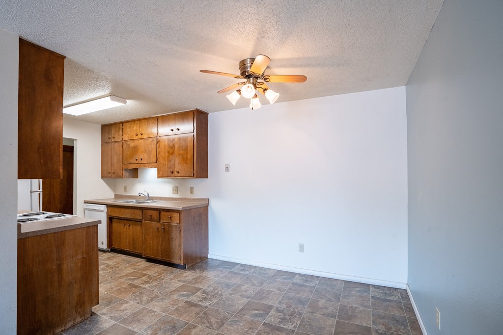 an empty kitchen and living room with a ceiling fan. Fargo, ND Betty Ann Apartments