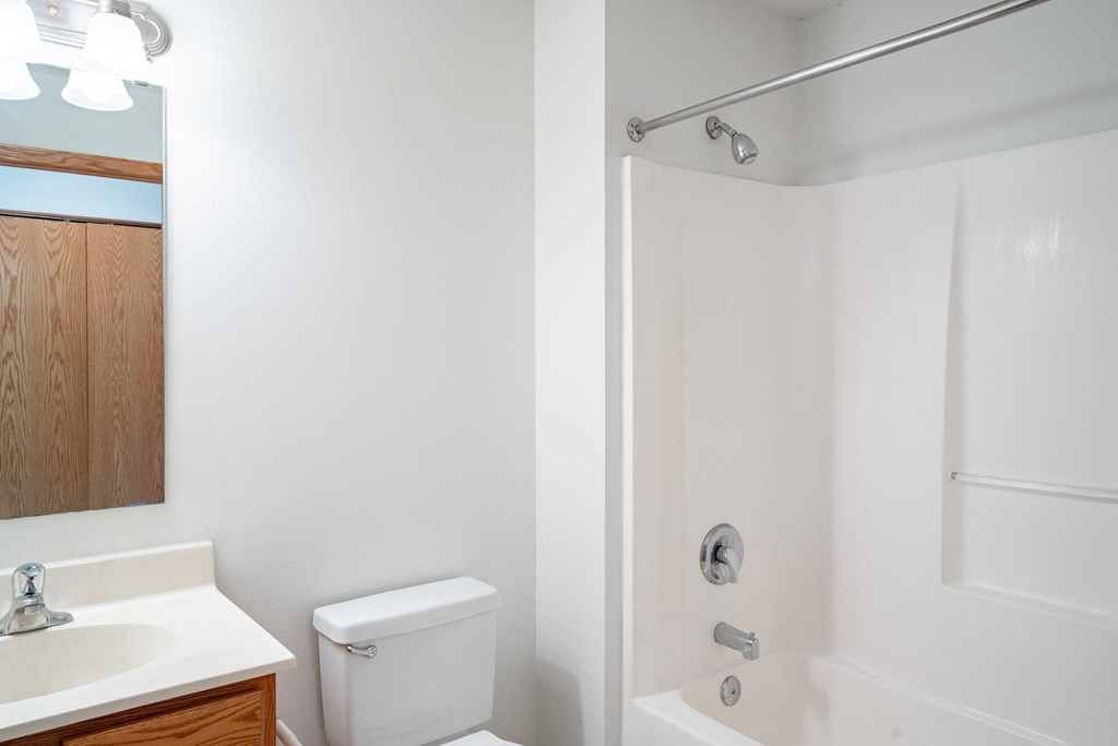 a bathroom with a toilet and a sink and a shower.  Eagan, MN Glen Pond Apartments