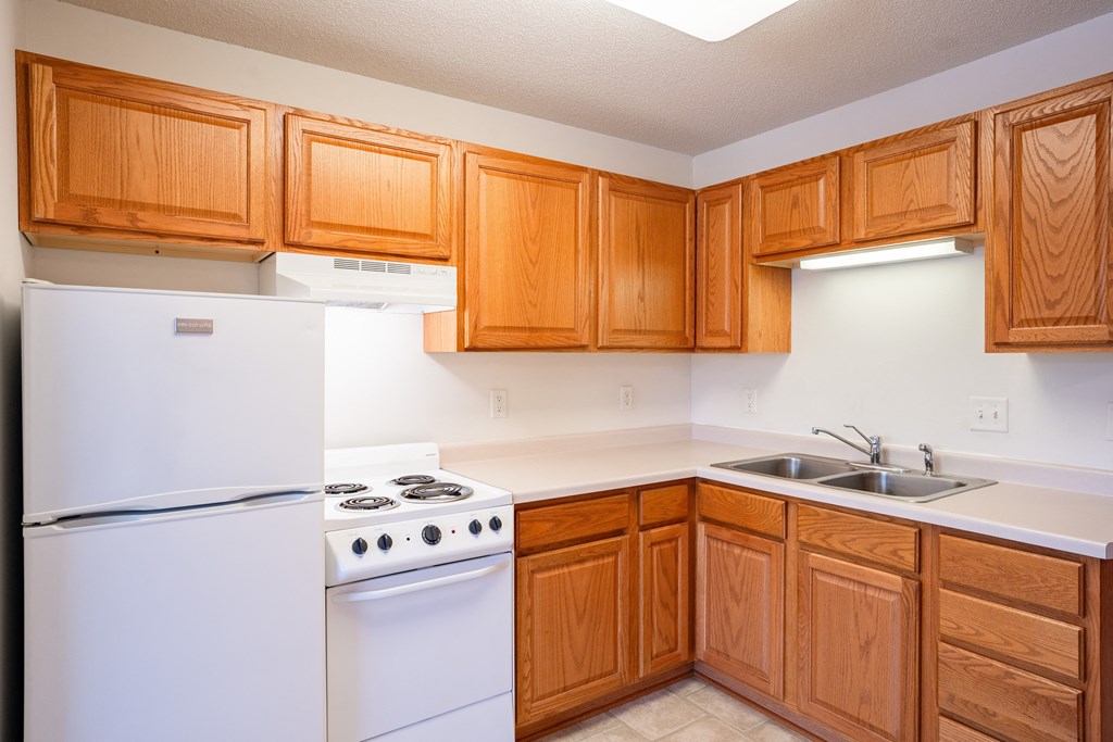 a kitchen with white appliances and wooden cabinets.  Eagan, MN Glen Pond Apartments