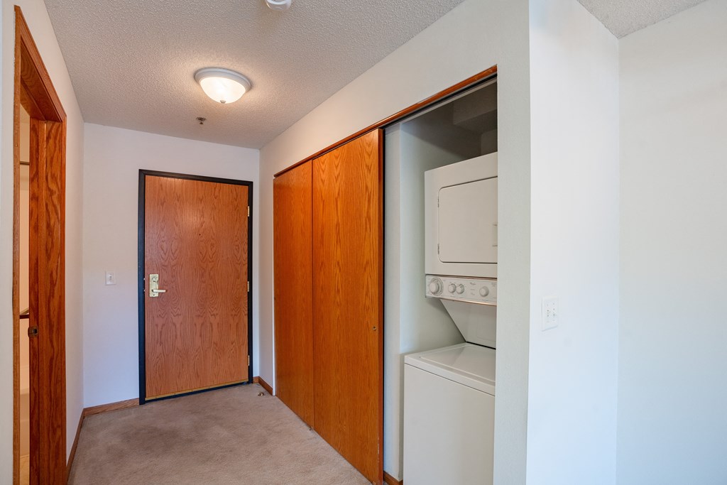 a laundry room with a washer and dryer and a door to a closet.  Eagan, MN Glen Pond Apartments