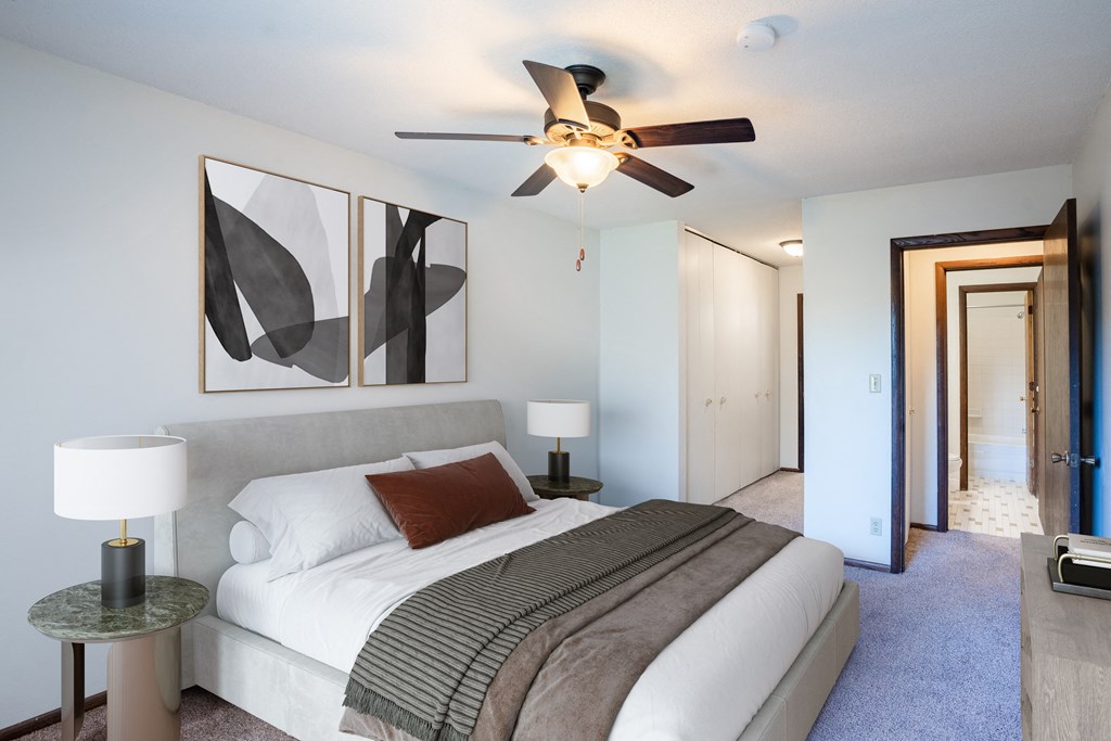 a bedroom with a large bed and a ceiling fan. Eagan, MN Glen Pond Apartments