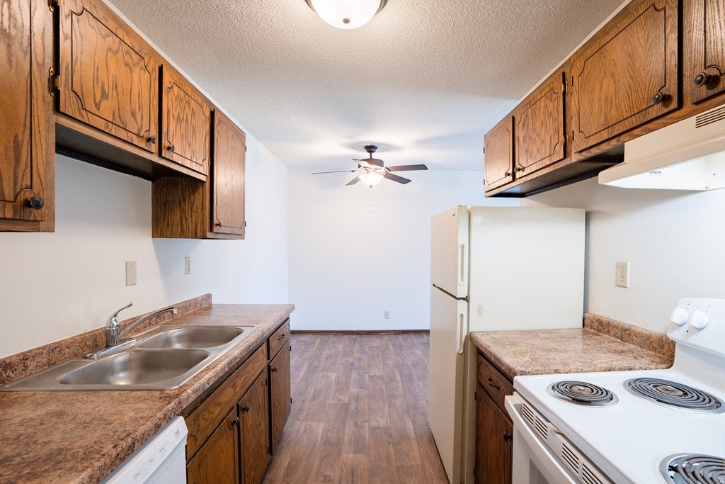 a kitchen with white appliances and wooden cabinets.  Eagan, MN Glen Pond Apartments
