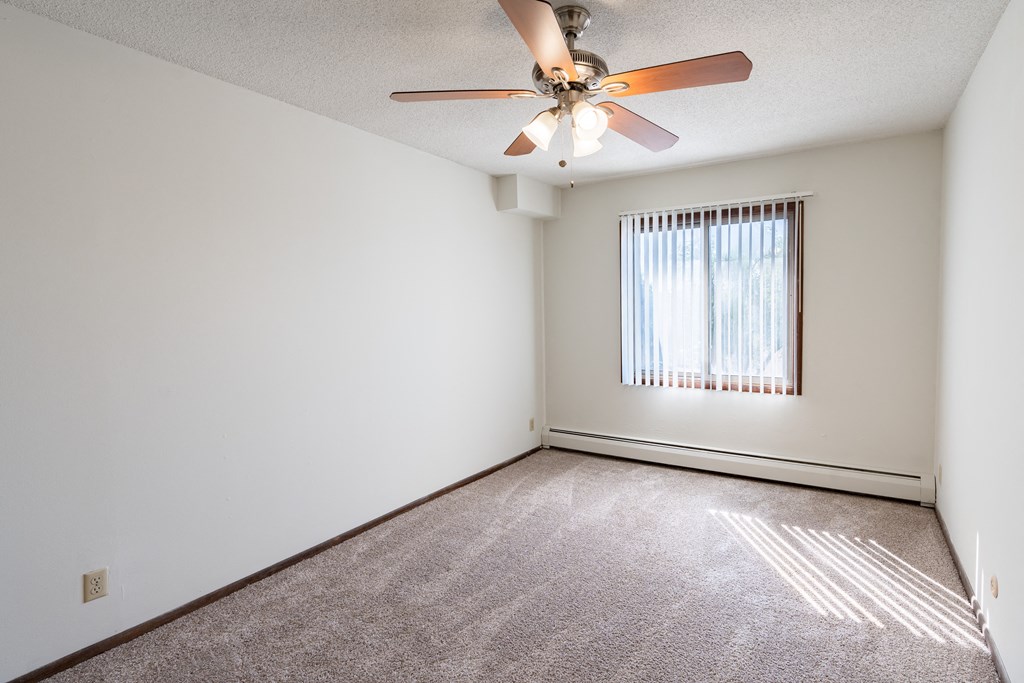 a bedroom with a ceiling fan and a window. Eagan, MN Glen Pond Apartments