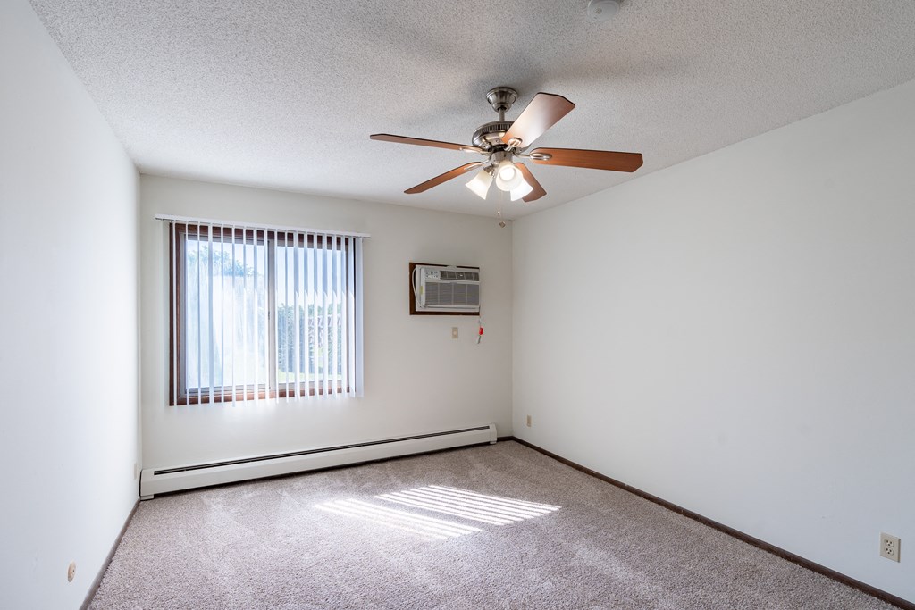 a bedroom with a ceiling fan and a window. Eagan, MN Glen Pond Apartments
