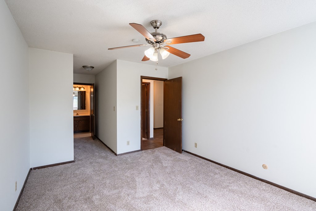 a bedroom with a ceiling fan and white walls. Eagan, MN Glen Pond Apartments