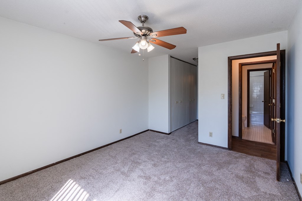a bedroom with white walls and a ceiling fan. Eagan, MN Glen Pond Apartments