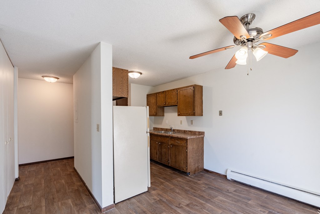 an empty kitchen with a ceiling fan and a refrigerator. Eagan, MN Glen Pond Apartments