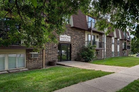 A brick building with a sign. Bismarck, ND Belmont West Apartments