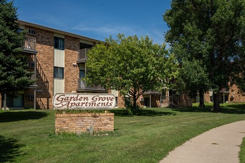 A brick building with a sign that says Garden Grove Apartments. Bismarck, ND Garden Grove Apartments