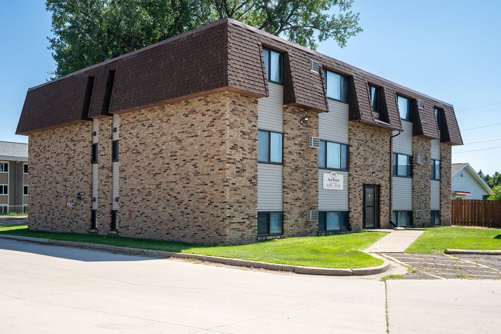 A brick building with a brown roof. Bismarck, ND Arbor 400 Apartments
