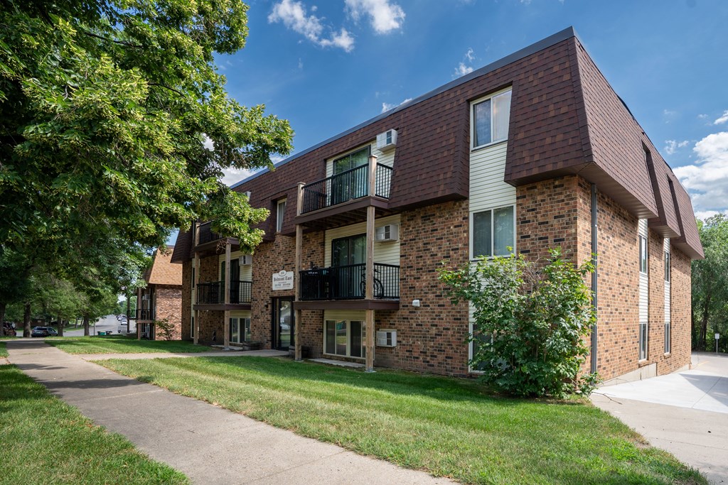 A brick building with a balcony on the second floor. Bismarck, ND Belmont East Apartments