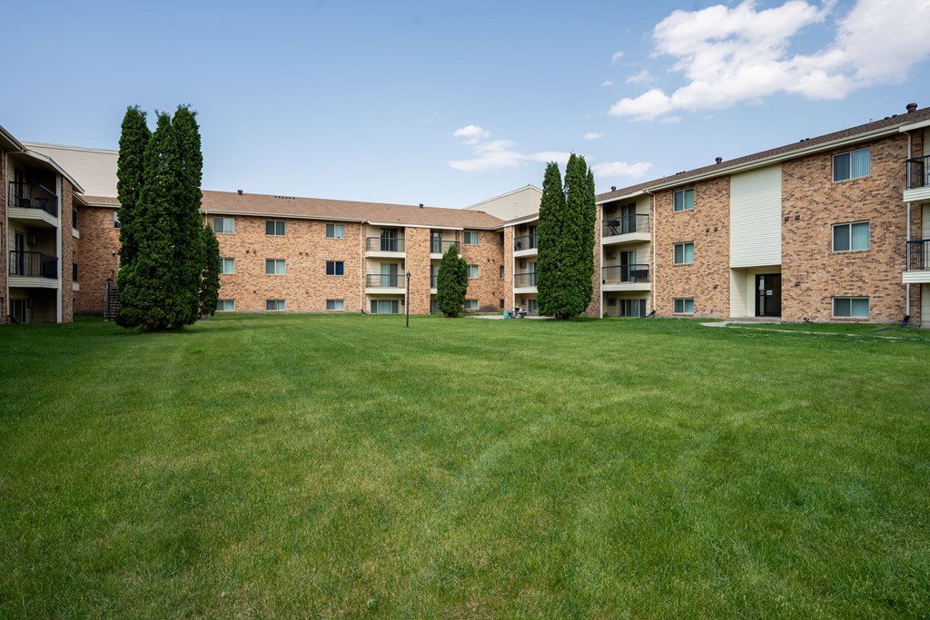 A grassy area in front of apartment buildings. Grand Forks, ND Columbia West Apartments