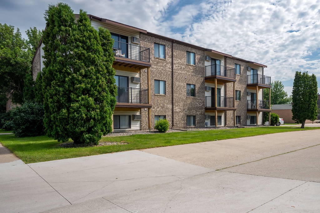 A large apartment complex with a parking lot in front. Fargo, ND Hawthorn Apartments