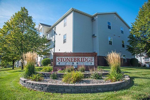 A building with a sign that says Stoneridge in front of it. Fargo, ND Stonebridge Apartments