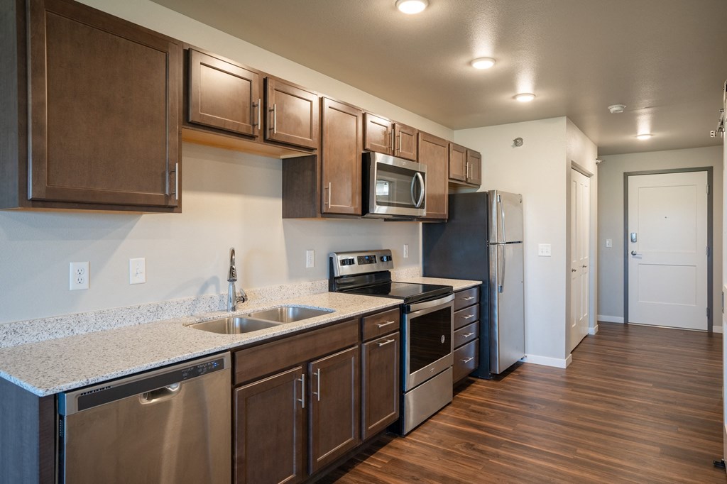 a kitchen with stainless steel appliances and a granite counter top. Fargo, ND 29 West Apartments