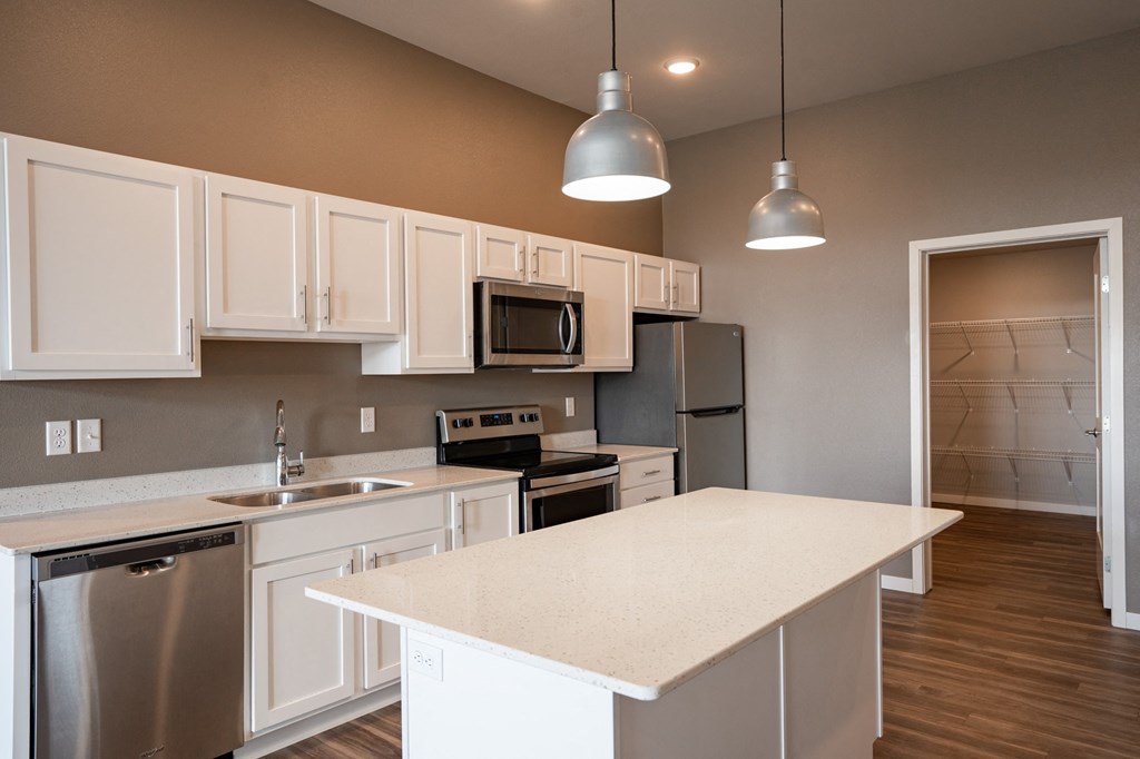 a kitchen with white cabinets and stainless steel appliances. Fargo, ND 29 West Apartments
