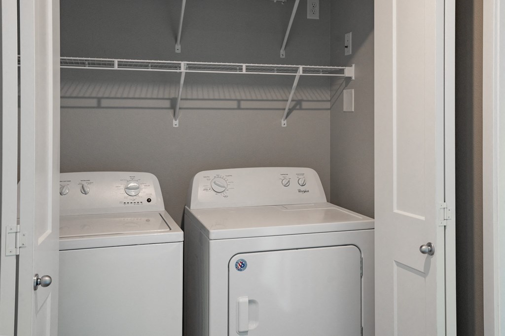 an empty laundry room with two washes and a dryer. Fargo, ND 29 West Apartments