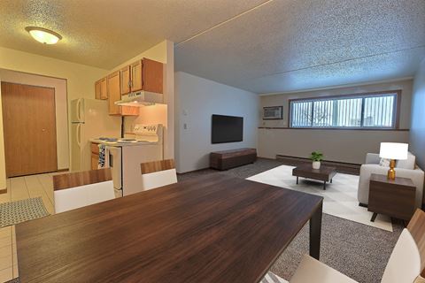 a living room and kitchen with a wooden table. Fargo, ND Alden Pines Apartments